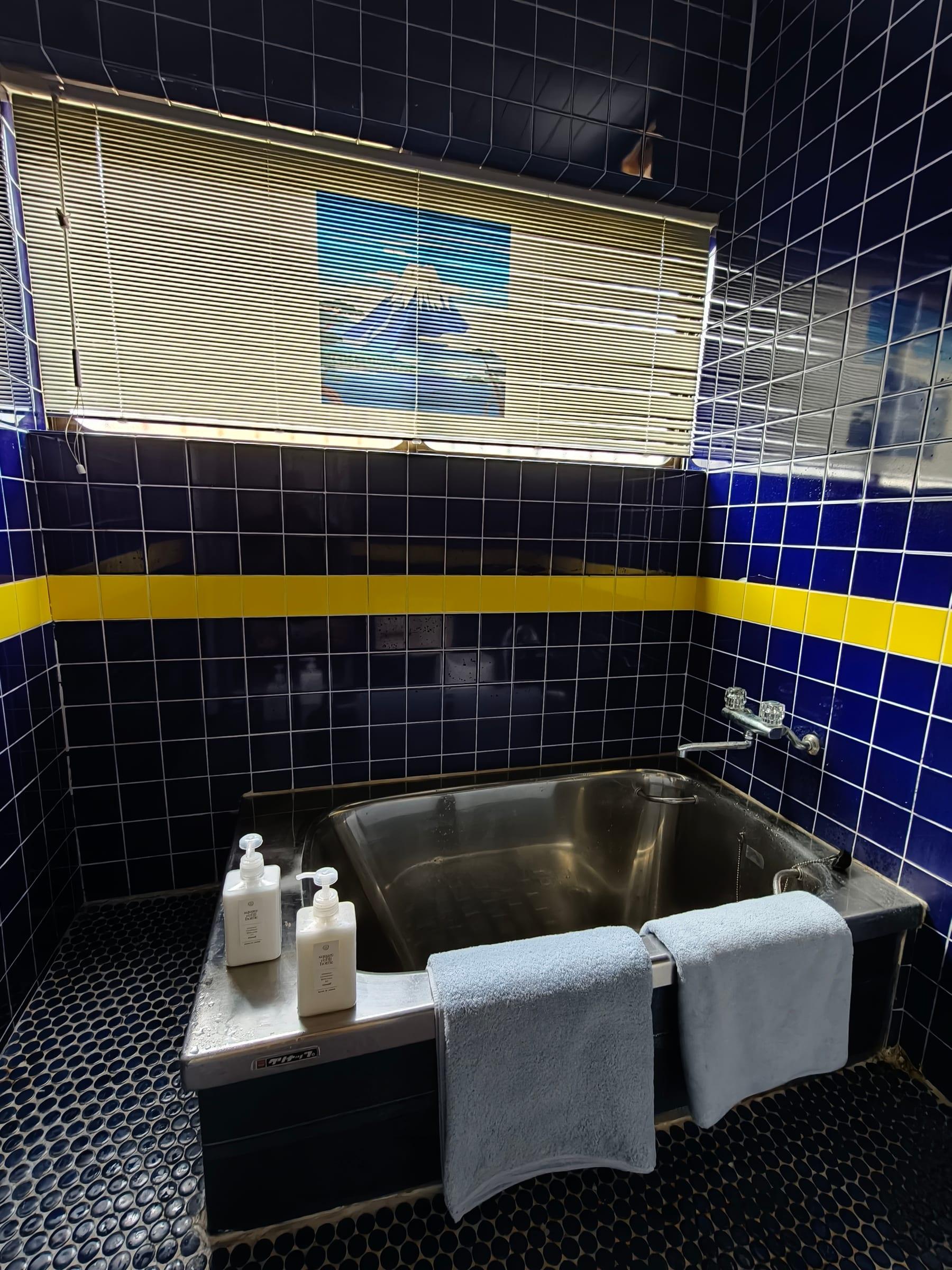Bathroom with blue tiles and a bathtub